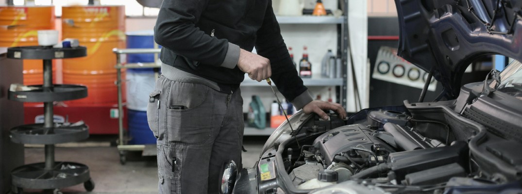A photo of a dealership tech working on a car.