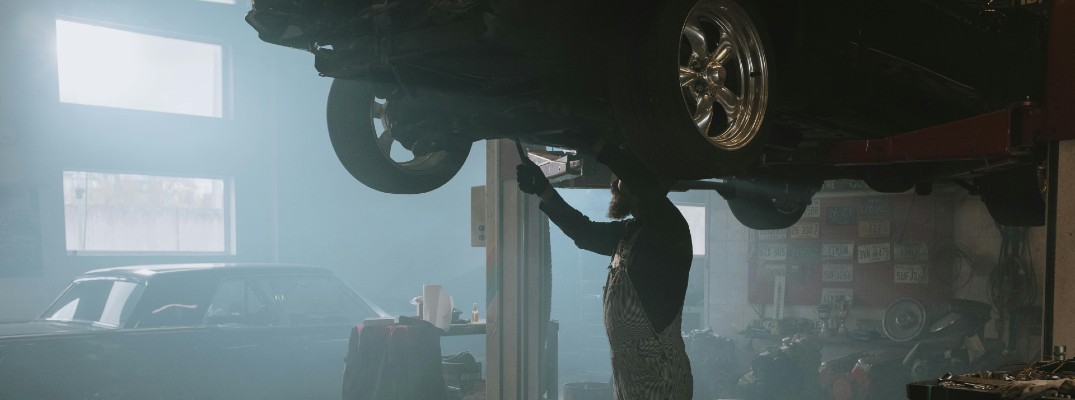 A stock photo of a person working on a car's tires.