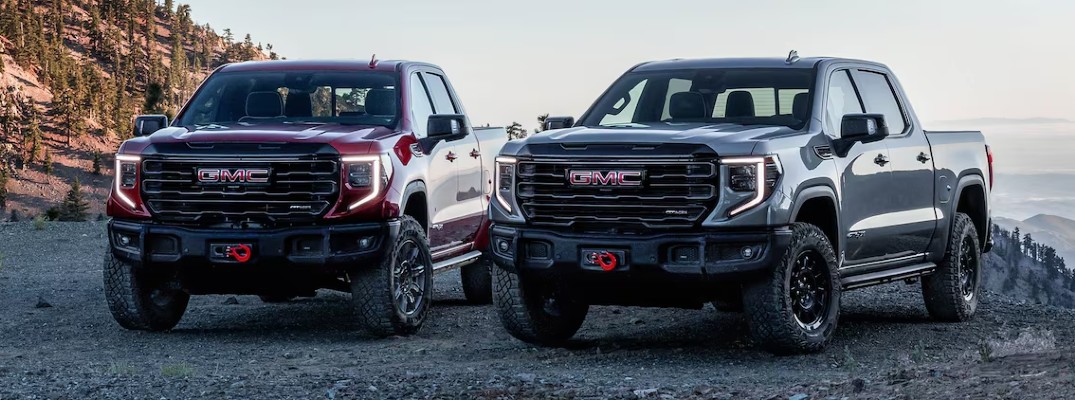 A photo of two trucks with four-wheel drive on the beach.